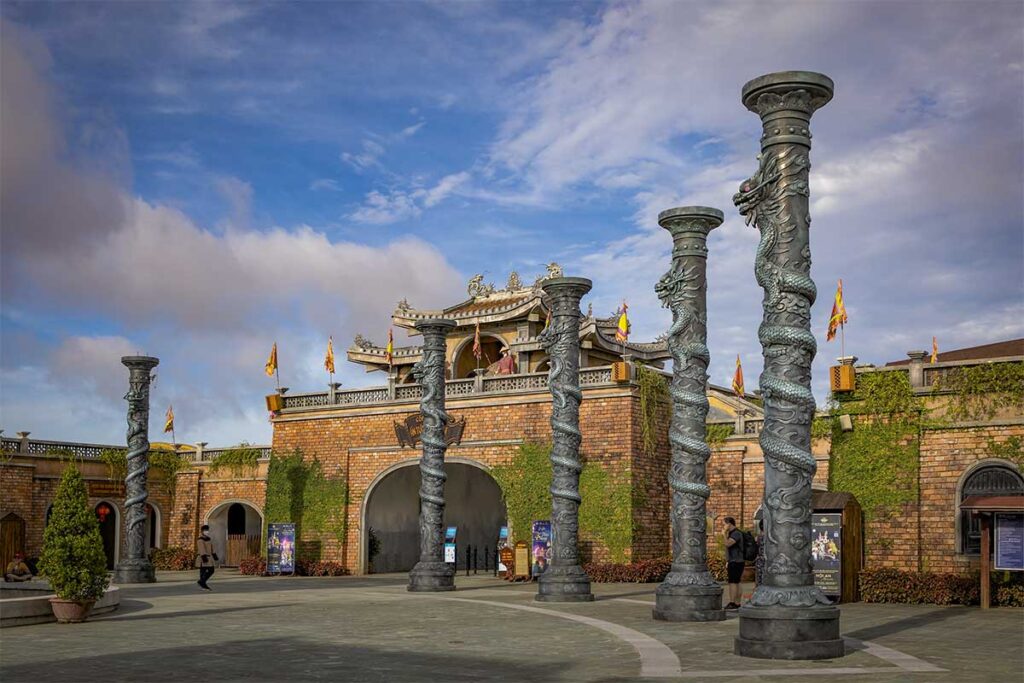 Entrance of Hoi An Memories Land with dragon pillars and traditional Vietnamese architecture.