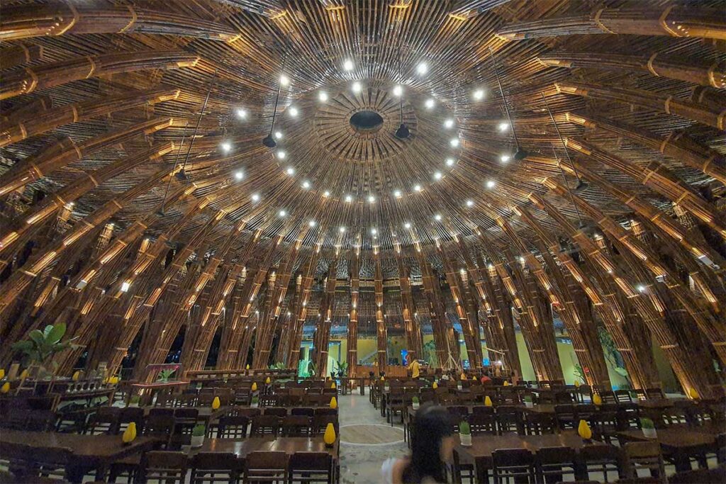 Interior of the Non La Restaurant at Hoi An Memories Land, featuring a unique bamboo dome ceiling with warm lighting