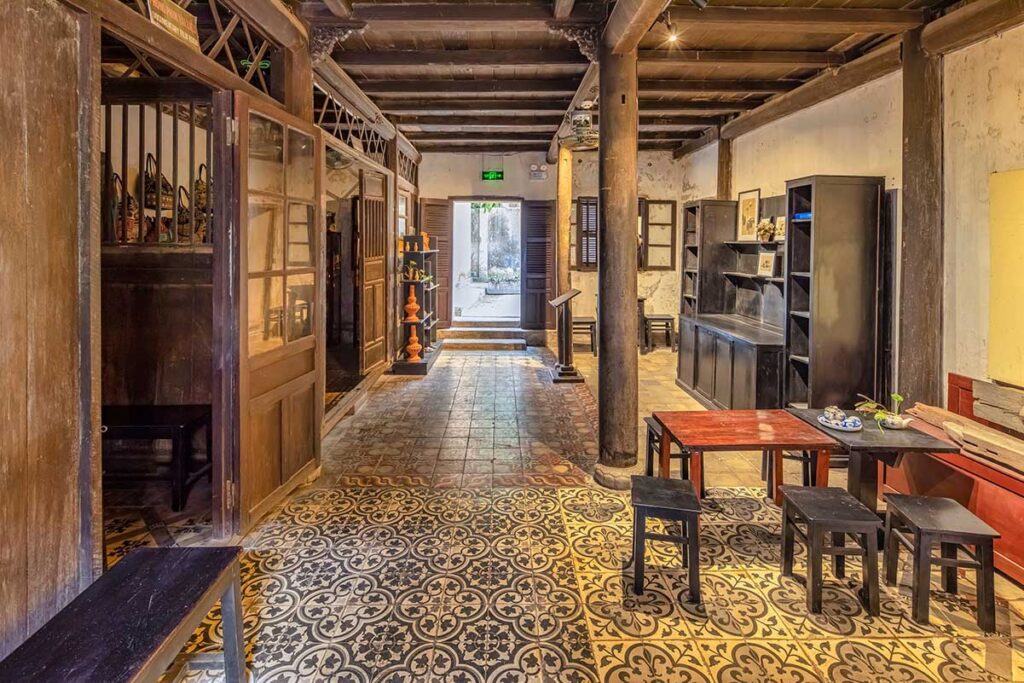 Interior hall of Hoi An Museum of Trade Ceramics with patterned floor tiles and antique wooden beams – highlighting the blend of Vietnamese and Japanese architectural influences.
