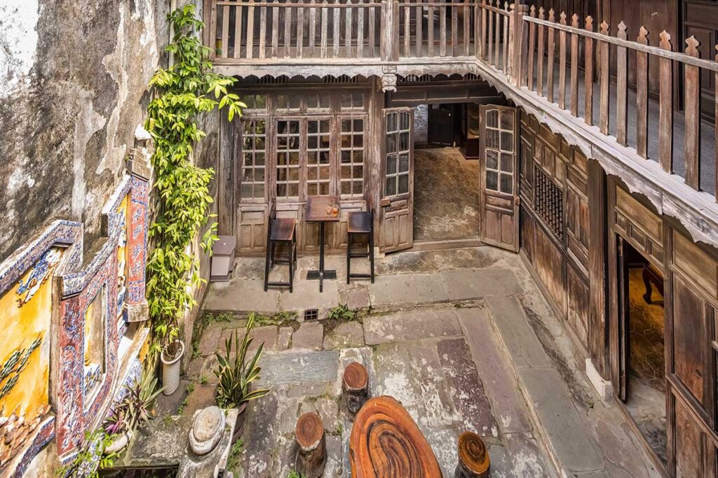Courtyard view inside Hoi An Museum of Trade Ceramics with traditional wooden balcony and rustic stone floors – showcasing preserved architecture of an ancient merchant’s house in Hoi An Ancient Town.