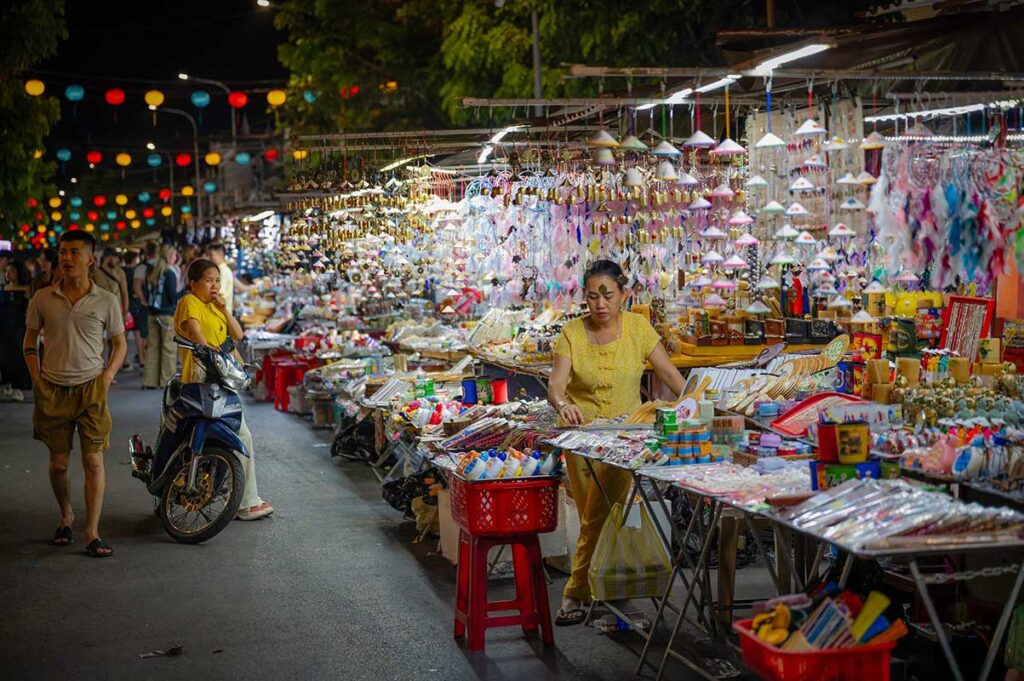 Souvenir stands selling handmade crafts, trinkets, and lanterns along the lively Hoi An Night Market.