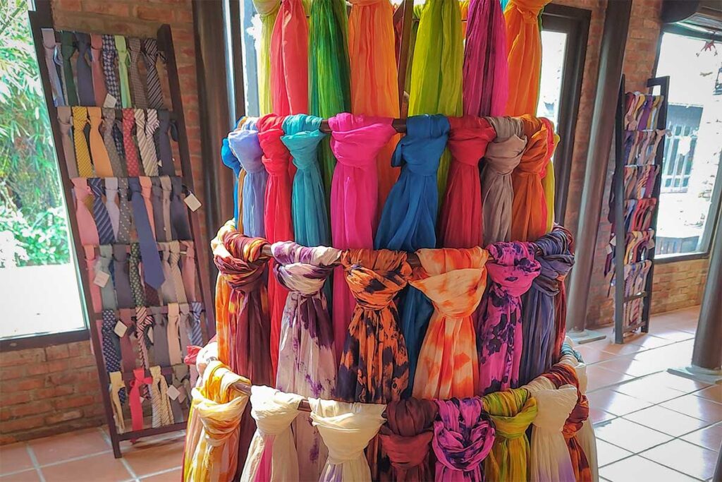 Vibrant silk scarves and ties for sale in the showroom of Hoi An Silk Village.