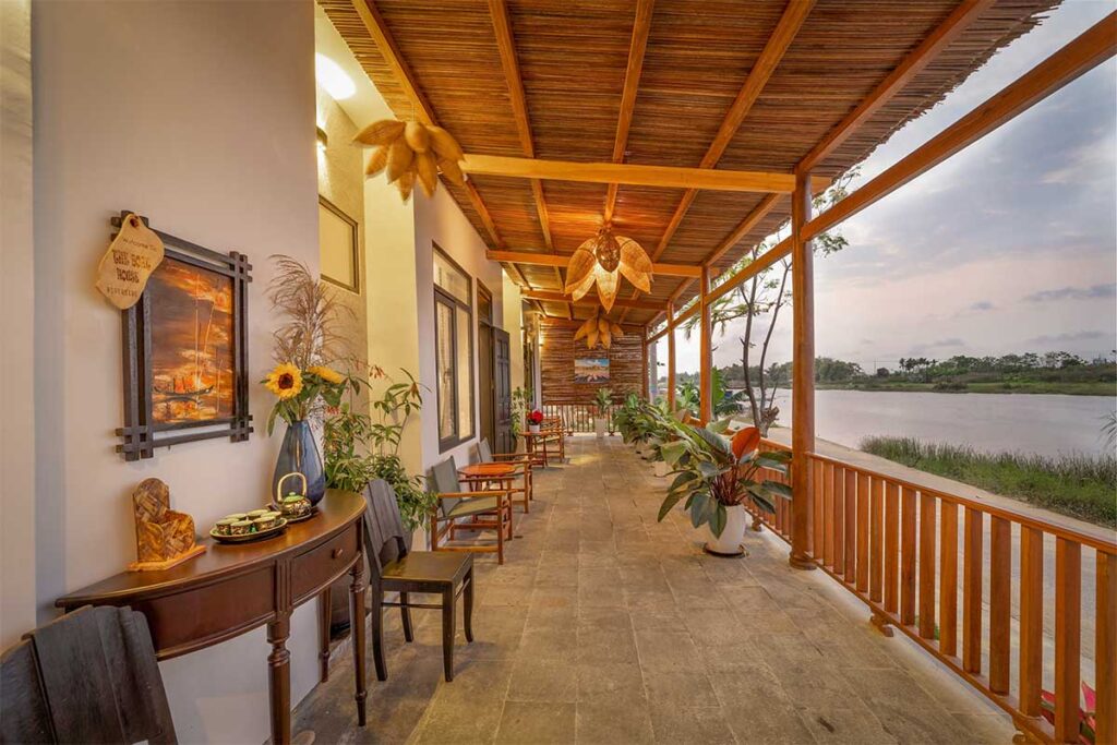 Riverside homestay on Cam Kim Island with bamboo-style architecture, wooden terrace, and peaceful views of the Thu Bon River near Hoi An