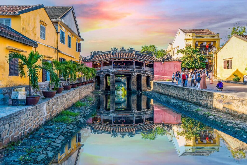 Japanese Bridge Hoi An at sunset – The Japanese Covered Bridge lit by golden skies at dusk, with groups of visitors gathering around to capture this symbol of Hoi An Ancient Town.