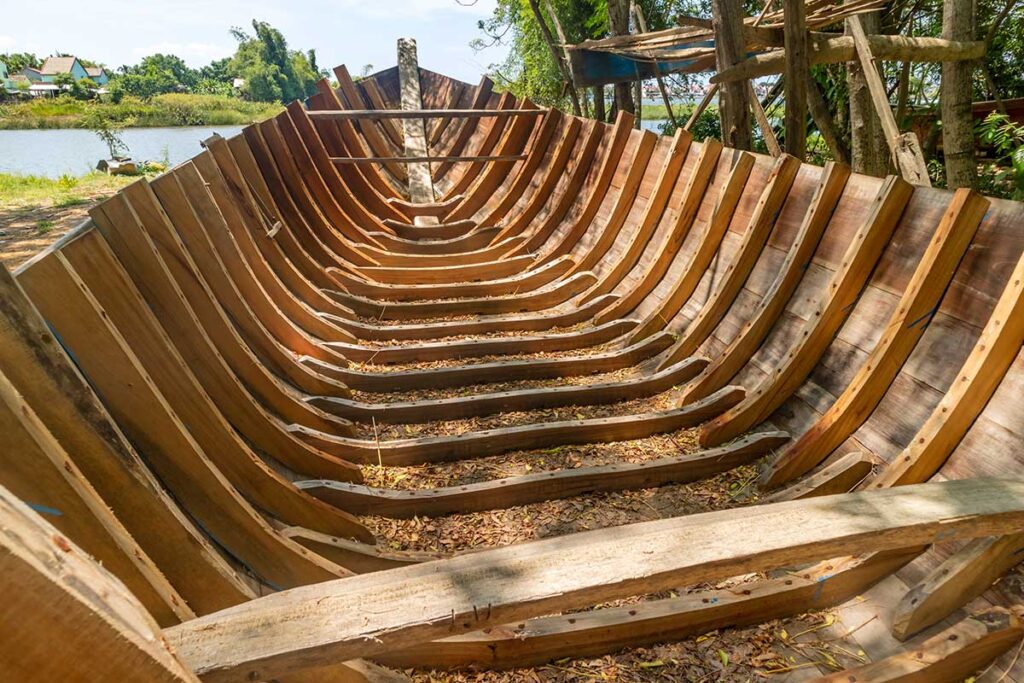Wooden boat skeleton showing traditional shipbuilding techniques in Kim Bong Village.