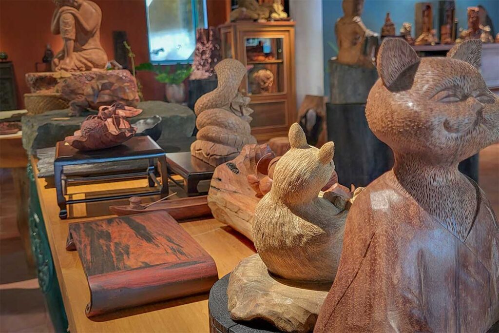 Interior of a Kim Bong Carpentry Village shop showcasing detailed wooden sculptures and carvings being sold for tourists