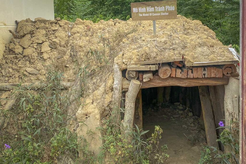 Model of a wartime cannon shelter at Ky Anh Tunnels, constructed from earth and logs to demonstrate local defense strategies during the Vietnam War.