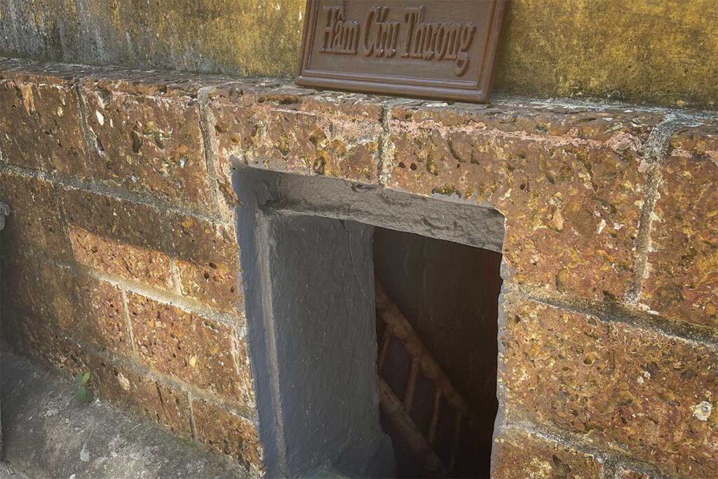 Brick entrance of Ky Anh Tunnels with narrow stairway leading underground in Quang Nam Province, Vietnam.