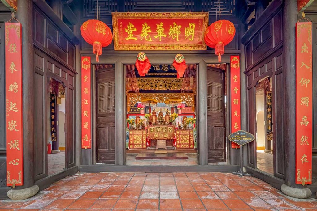 Entrance of Minh Huong Pagoda in Hoi An Old Town, decorated with red lanterns and golden altars honoring ancestors and local deities.