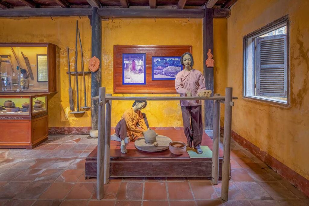 Crafts gallery at the Hoi An Folklore museum with mannequins demonstrating Thanh Ha pottery making and traditional tools.