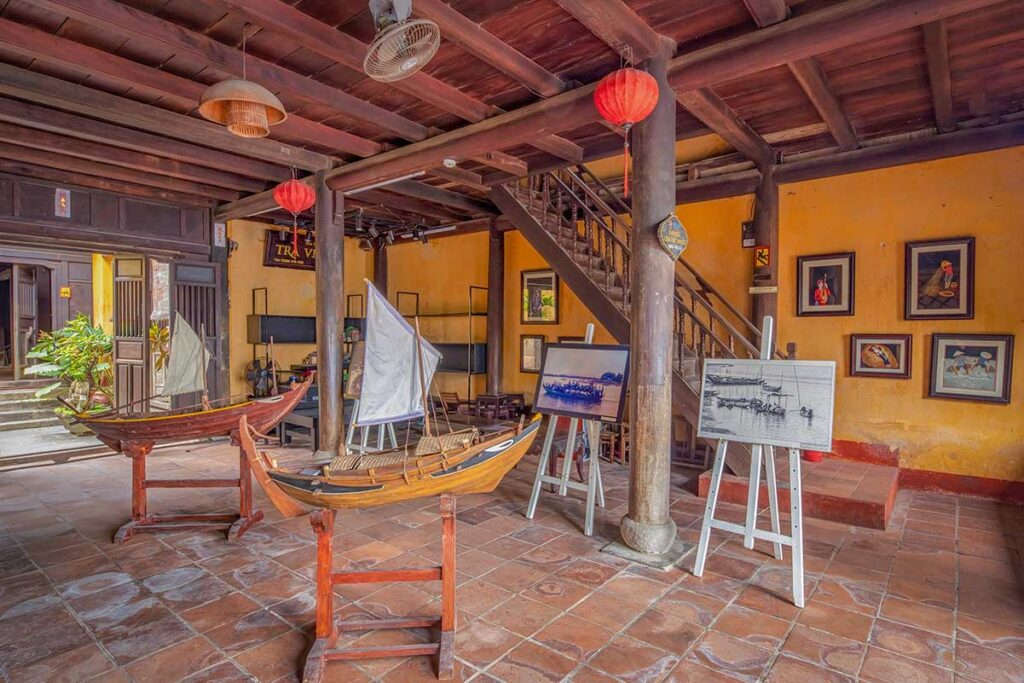 Ground-floor exhibit at the Hoi An Folklore museum showcasing model boats and coastal life paintings representing the town’s trading heritage