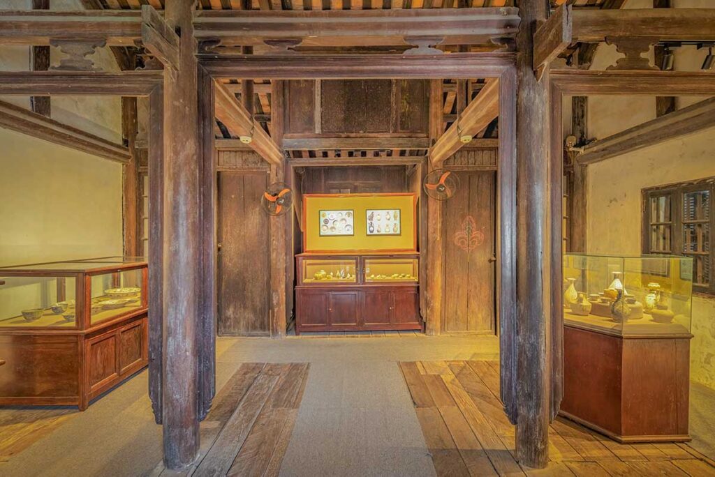 Interior of the Museum of Trade Ceramics in Hoi An Old Town, displaying ancient pottery and maritime artifacts inside a restored wooden merchant house.
