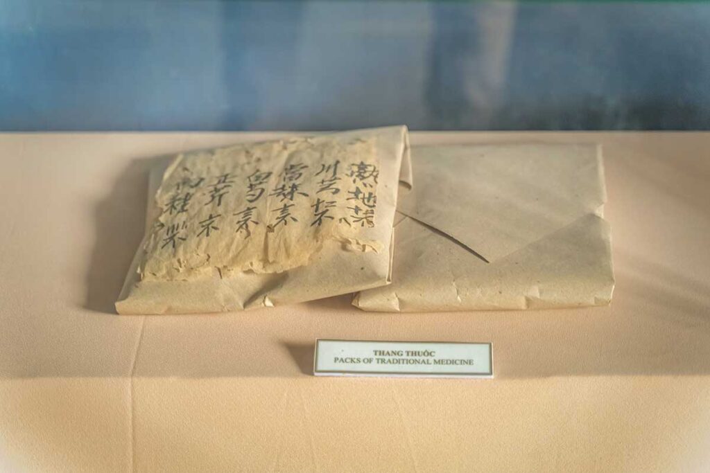 Display of traditional Vietnamese herbal medicine packs with ancient script at the Museum of Traditional Medicine in Hoi An