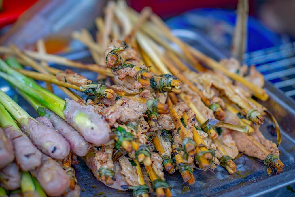 Grilled nem lụi pork skewers from Hoi An, wrapped around lemongrass sticks and tied with herbs, a popular Central Vietnam street food.