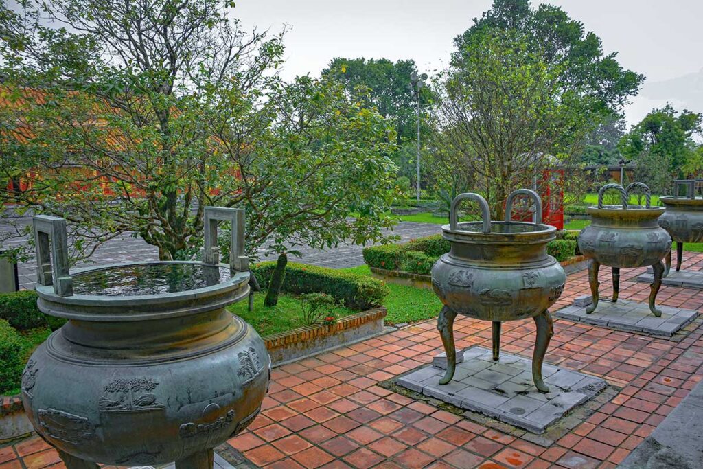 Four visible huge bronze urns part of the Nine Dynastic Urns (Cửu Đỉnh) within Hue Imperial City