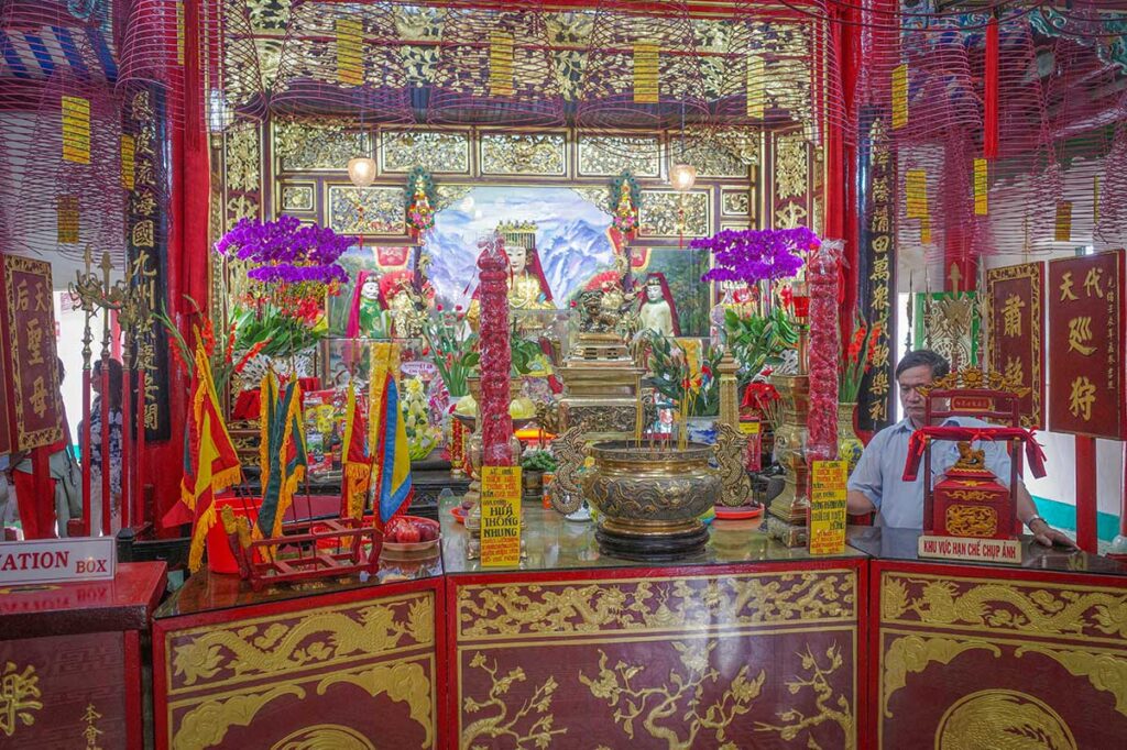 Vibrant main altar at Phuc Kien Assembly Hall, one of the most visited temples in Hoi An, richly decorated with dragons, offerings, and incense coils.