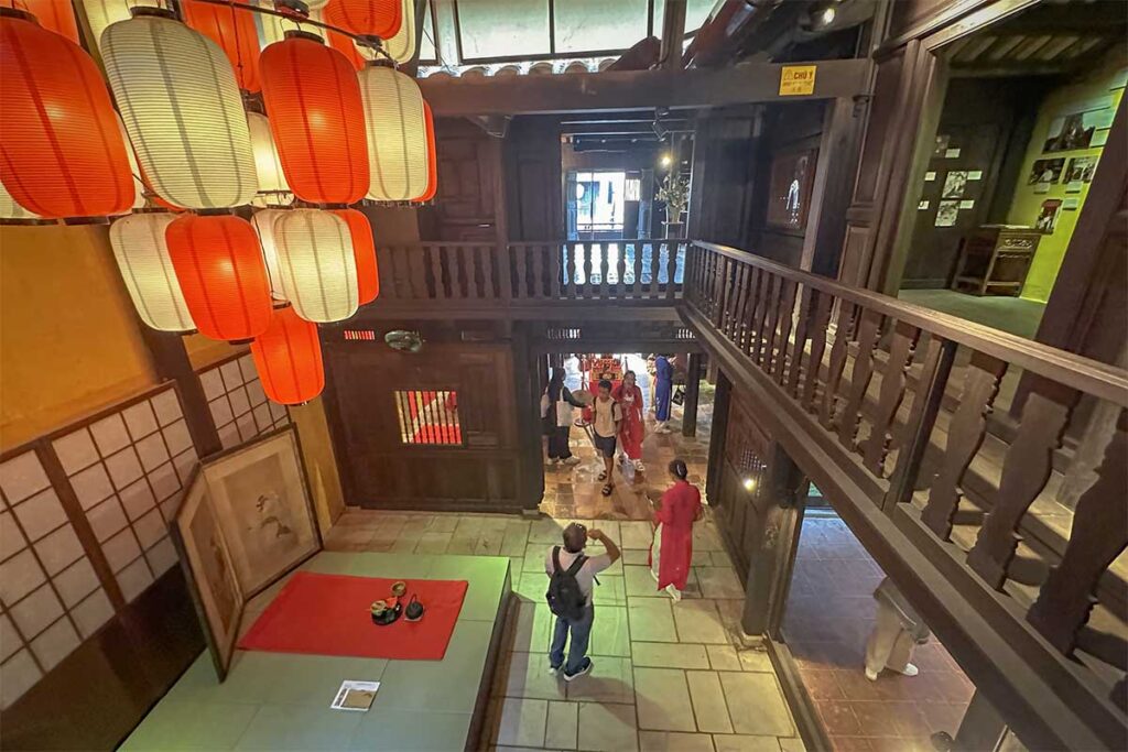 Ancient altar space inside Phung Hung Old House, decorated with red and yellow cloth, wooden statues, and lacquered furniture showcasing Hoi An’s cultural traditions.
