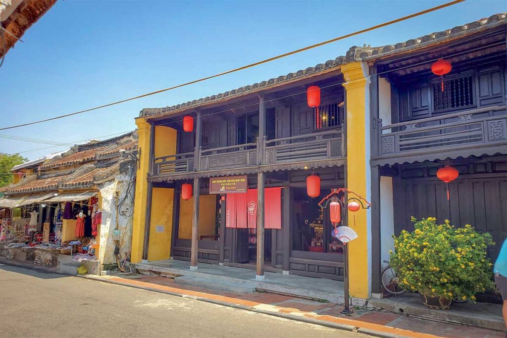 Exterior of Phung Hung Old House in Hoi An Ancient Town, a preserved wooden merchant house with yellow walls and red lanterns.