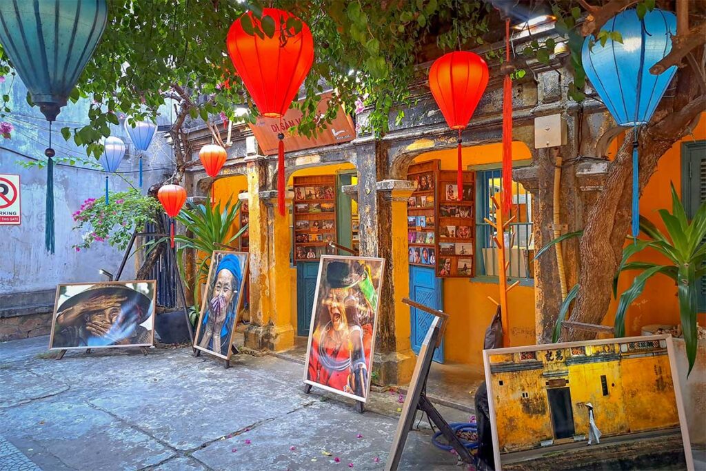 Courtyard of Precious Heritage Museum with lanterns and photo art – Outdoor gallery decorated with colorful lanterns and portraits of Vietnamese people.