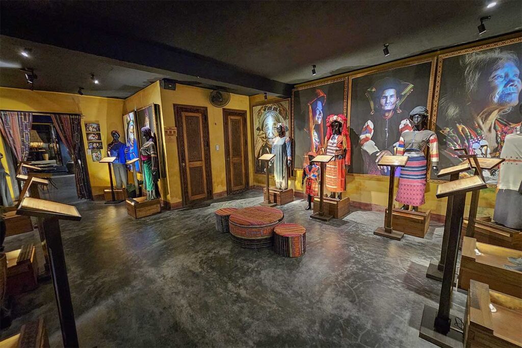 Exhibition room at Precious Heritage Museum by Réhahn – Traditional costumes and life-size portraits of Vietnam’s ethnic minorities displayed with descriptive panels.