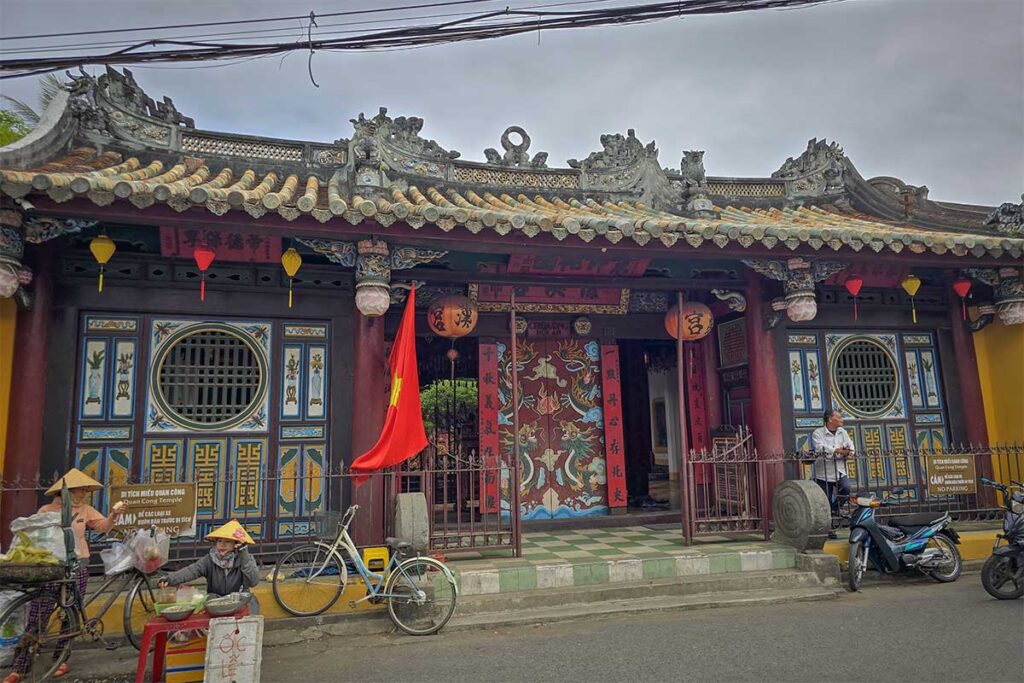 Front entrance of Quan Cong Temple in Hoi An with Vietnamese flag and lanterns