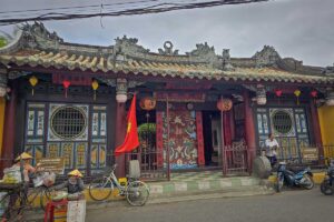 Front entrance of Quan Cong Temple in Hoi An with Vietnamese flag and lanterns