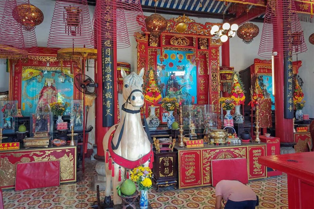 Colorful altar with horse statue and incense coils at Quan Cong Temple in Hoi An