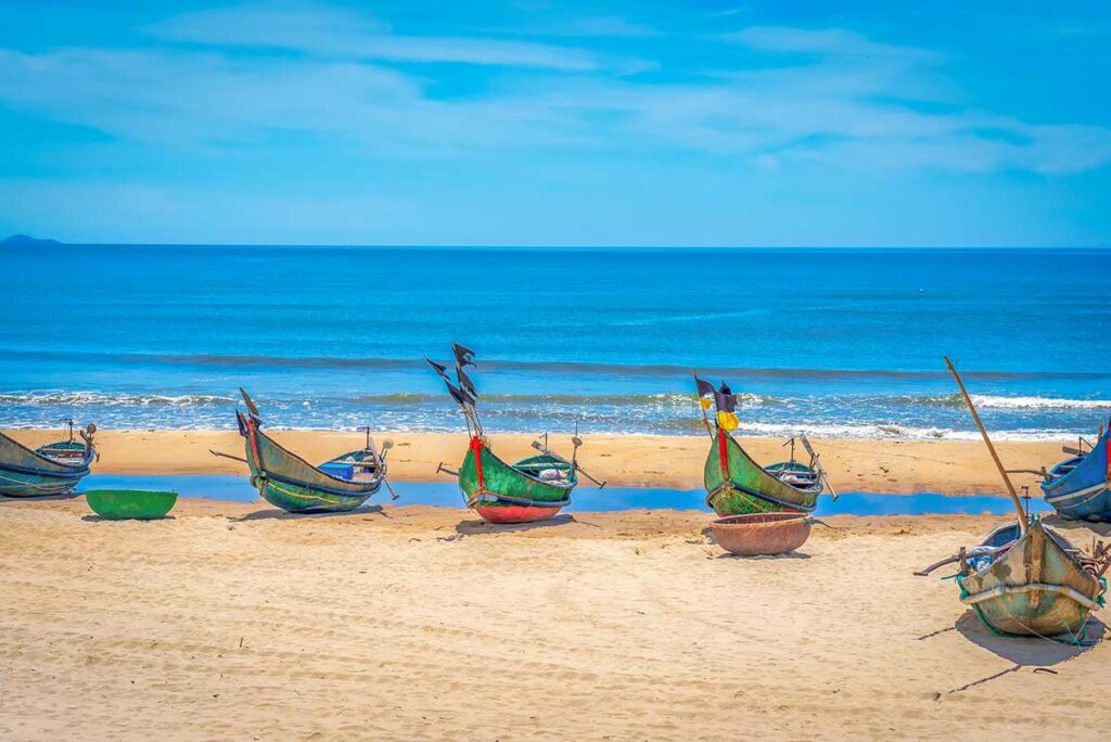 Crystal-clear blue waters and calm waves rolling onto Tam Thanh Beach, a peaceful coastal escape in Quang Nam Province.