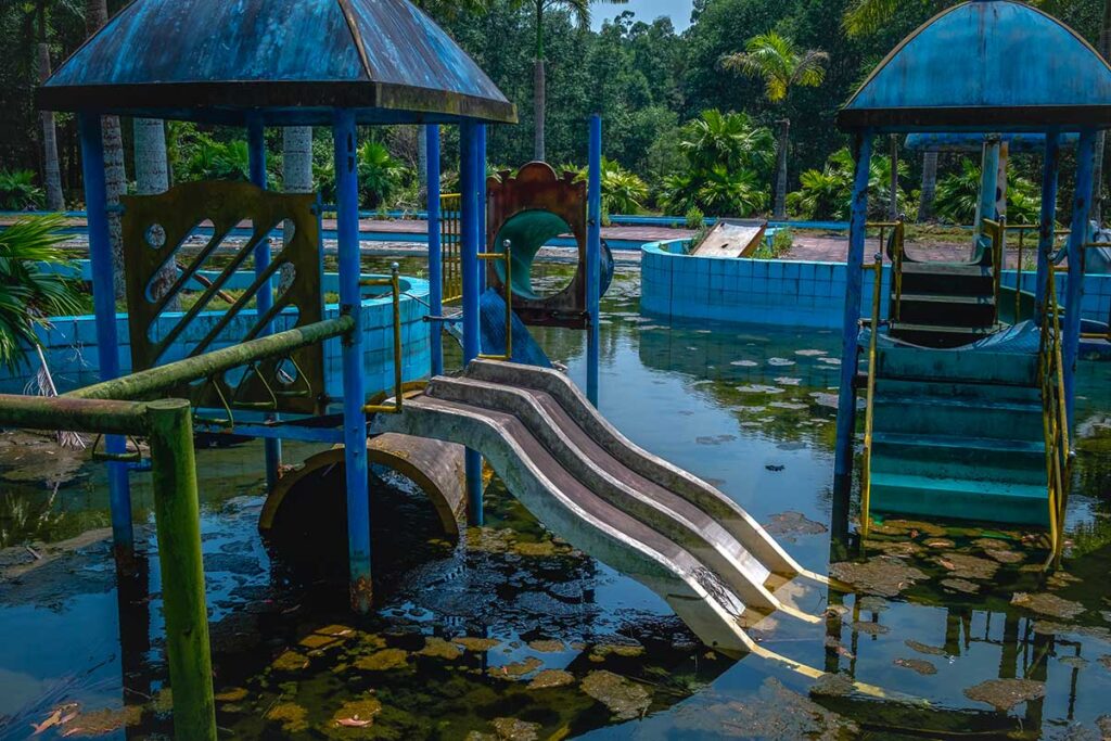 Overgrown water slides at Thuy Tien abandoned waterpark in Hue