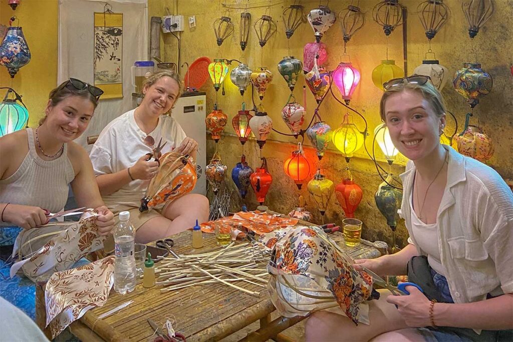 Travelers decorating fabric-covered lanterns in a lively lantern making class in Hoi An.