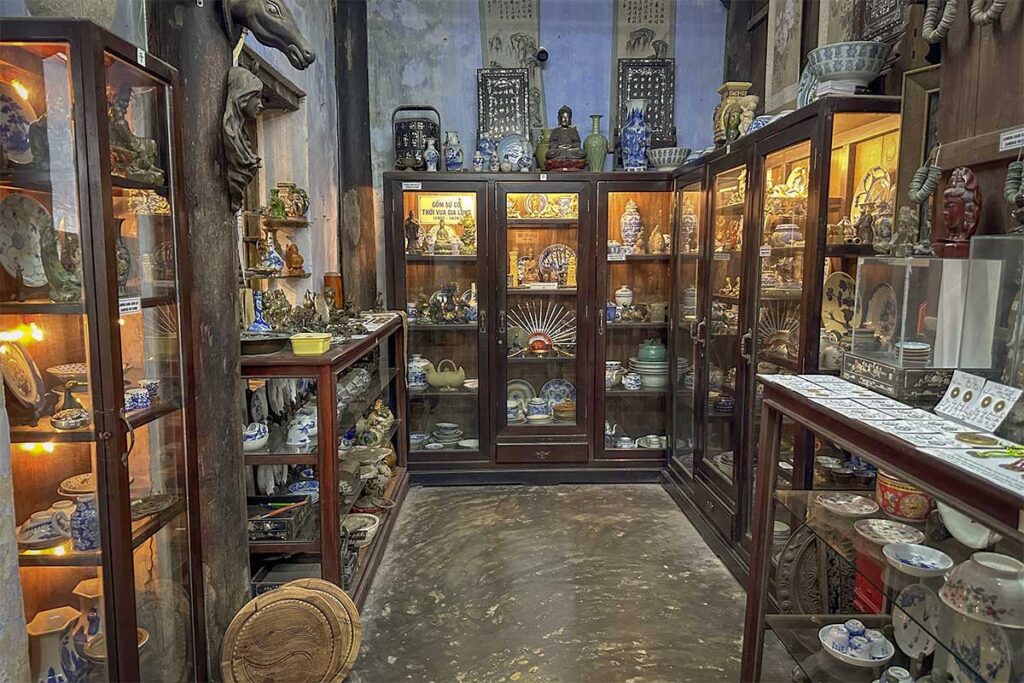 Souvenir area of Tran Family Chapel in Hoi An with ceramic vases, coins and vintage items.