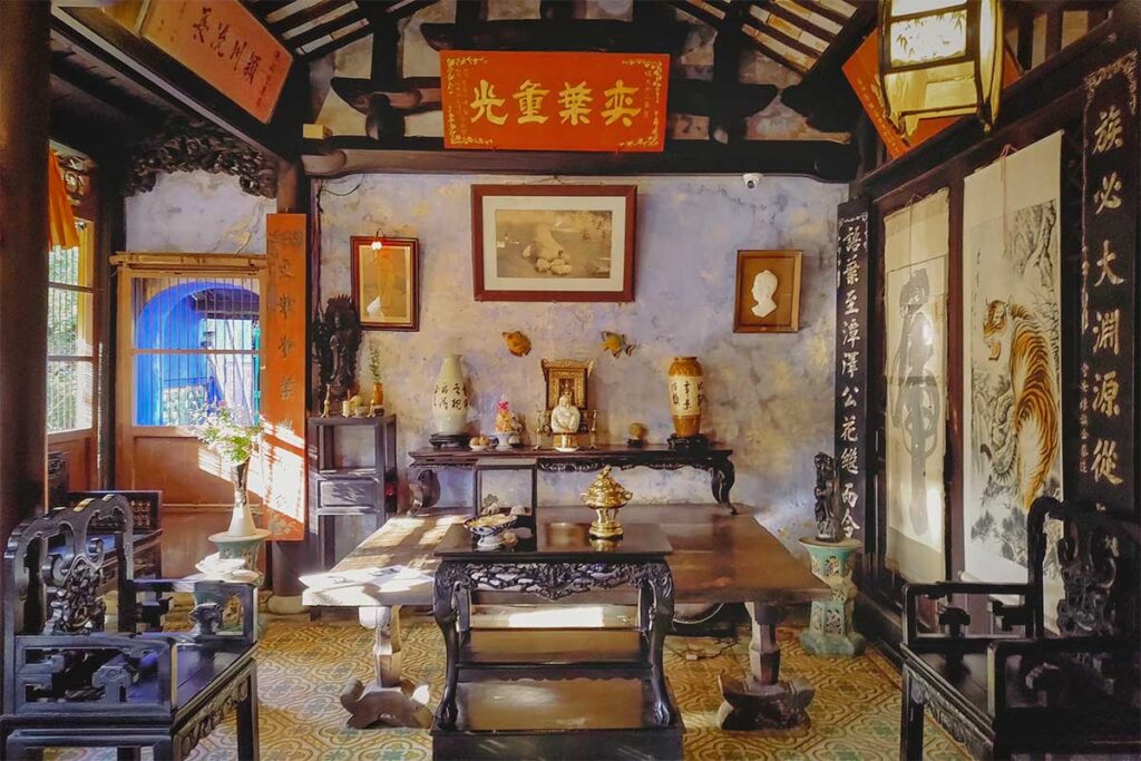 Room at Tran Family Chapel, decorated with red calligraphy panels, wooden furniture, and historic ornaments.