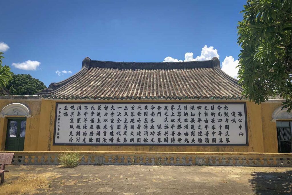 Exterior wall at Trung Hoa Assembly Hall displaying a large Chinese calligraphy panel of Sun Yat-sen’s teachings on a yellow facade.