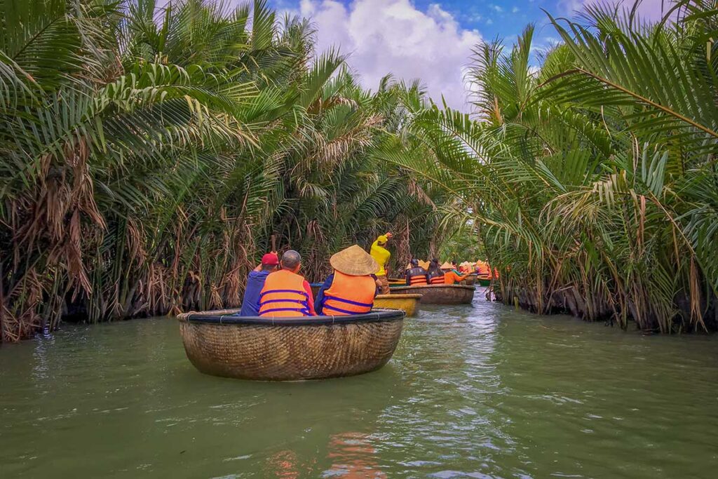 Row of basket boats carrying tourists through the canals of Cam Thanh Village coconut forest.