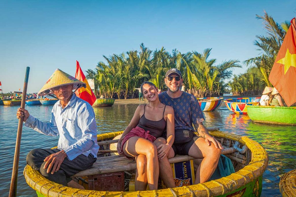 Local boatman and travelers enjoying a basket boat ride through the coconut waterways of Cam Thanh Village near Hoi An.