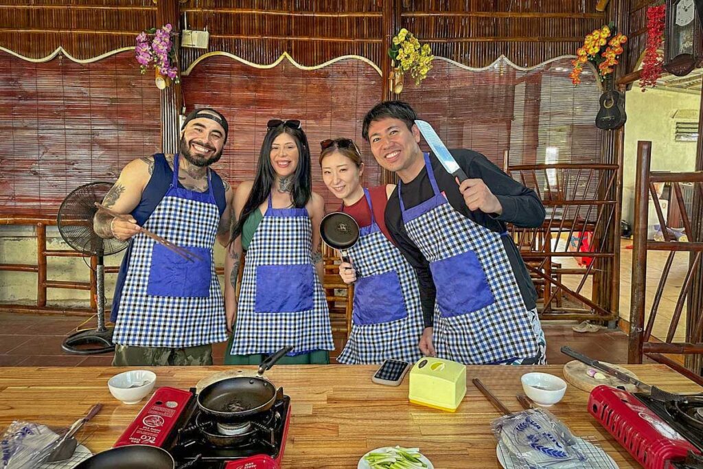 ravelers taking part in a hands-on Vietnamese cooking class in Cam Thanh Coconut Village, a popular cultural experience in Cam Thanh Village.