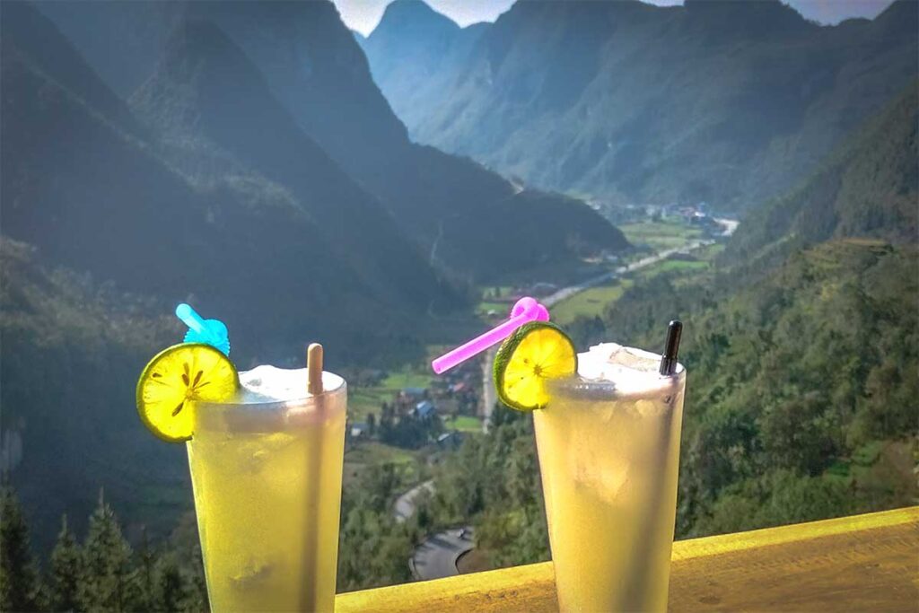 Two longtail glasses with drink inside on a table facing mountain views from a coffee shop on Chin Khoanh Pass