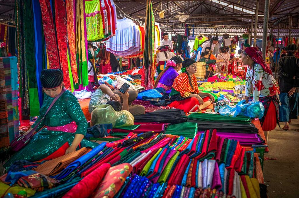 Lots of colorful clothes on stalls being sold at the Dong Van Market in Ha Giang