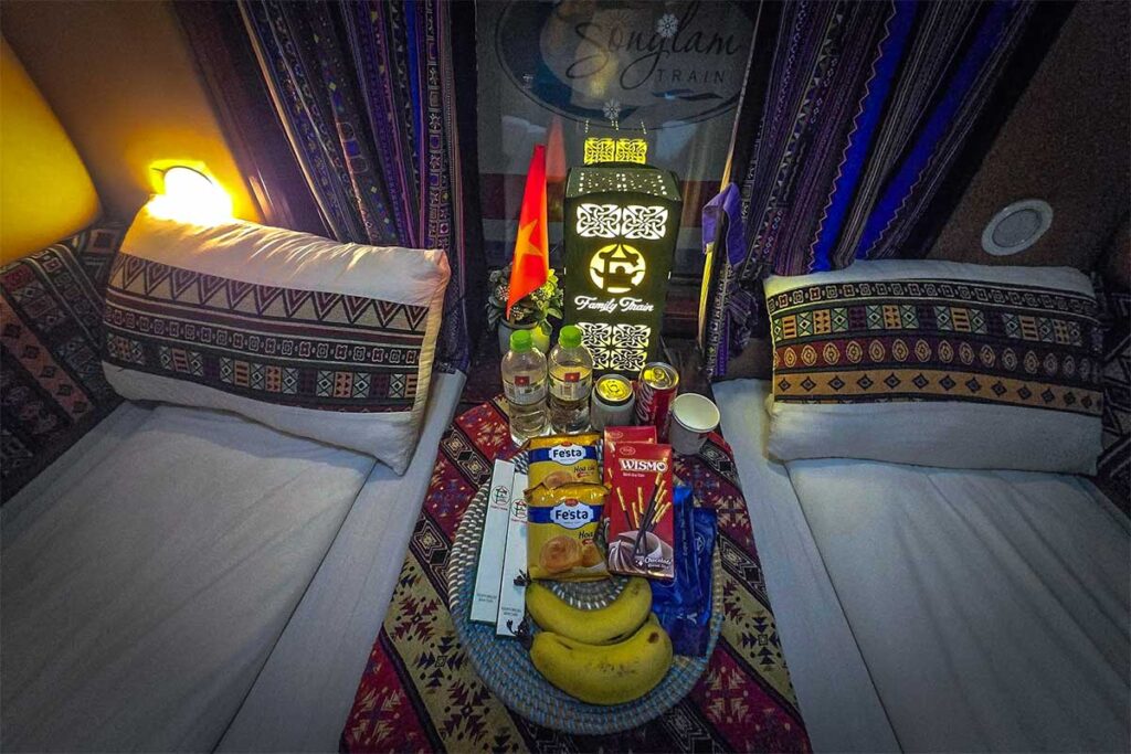 A food basket with snacks, drinks and fruit inside a train cabin of Family Express to Sapa