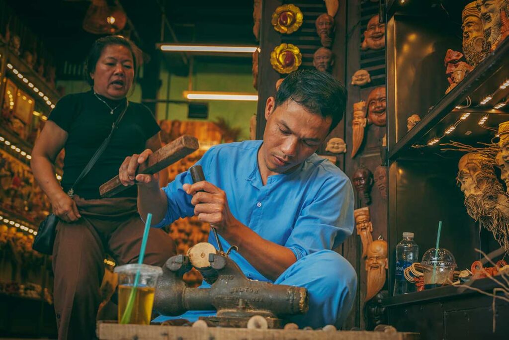 Artisan carving wooden masks in a traditional workshop – an authentic craft experience found in Hoi An’s artisan villages.