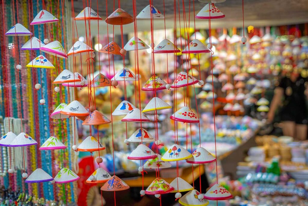 Mini conical hat keychains and ornaments displayed in a Hoi An souvenir stall, representing Vietnamese culture.