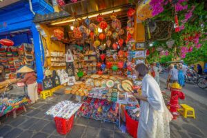 Street souvenir shop in Hoi An Old Town selling lanterns, handbags, fans, and handicrafts to visitors.