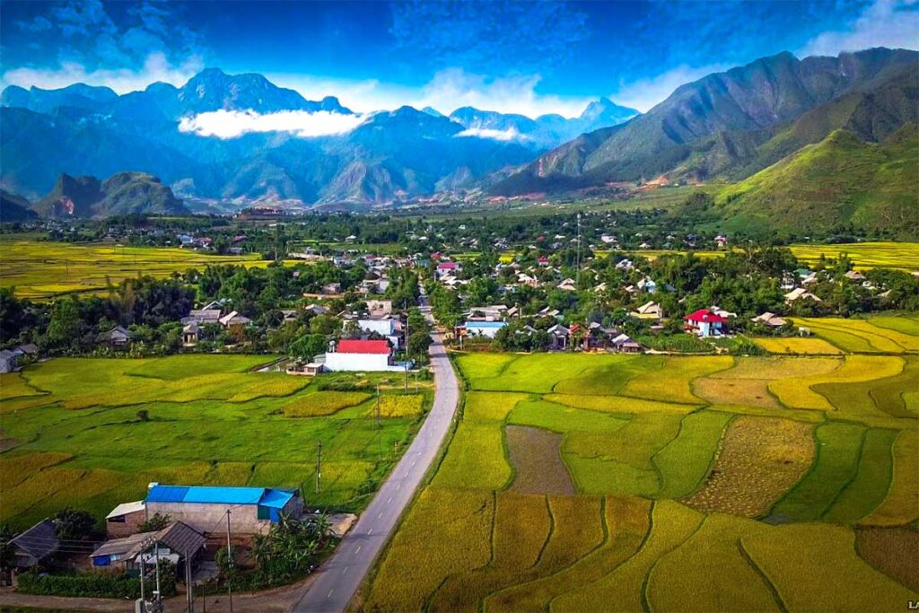 A road passing a small town and rice fields in Muong Than
