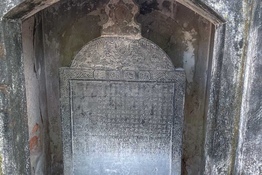 Ancient stone stele with Chinese inscriptions at Boc Pagoda in Hanoi, documenting the temple’s 17th-century origins and historical restorations