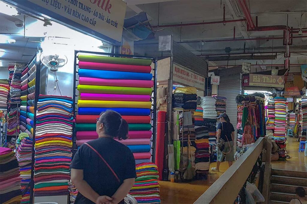 A woman browsing at one of the stalls full of silk at the Hom Market in Hanoi