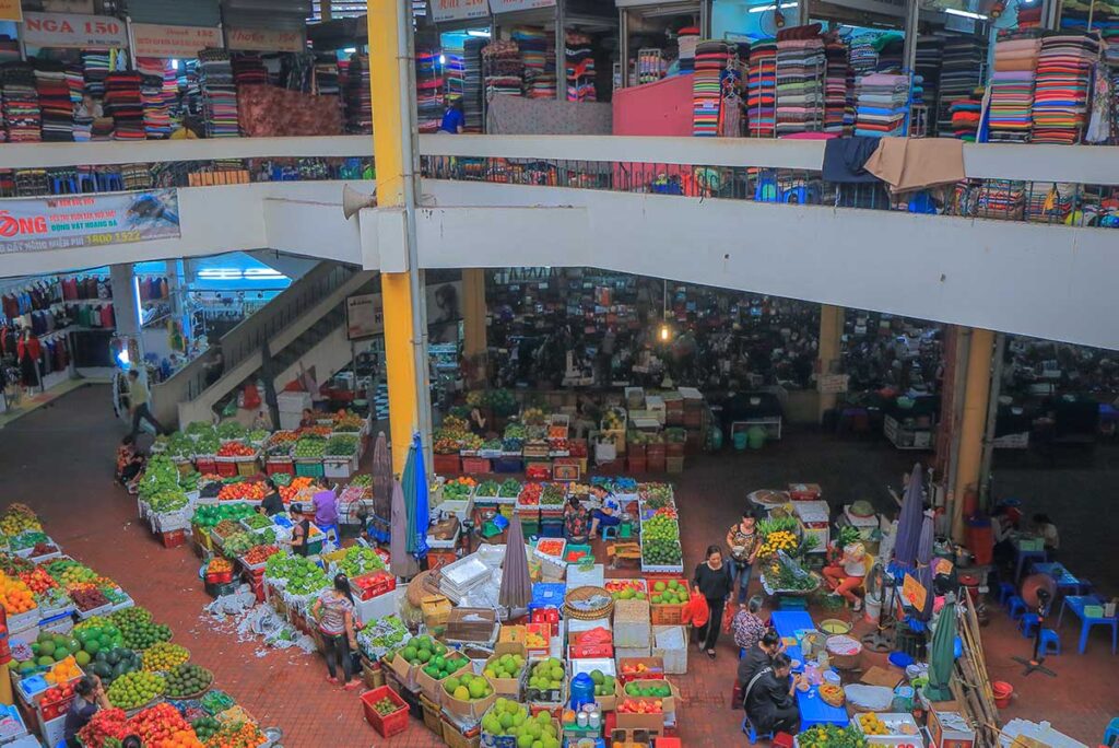 The view from second floor of Hom Market seeing the ground floor with fruit, vegetables and upstairs area full of silk