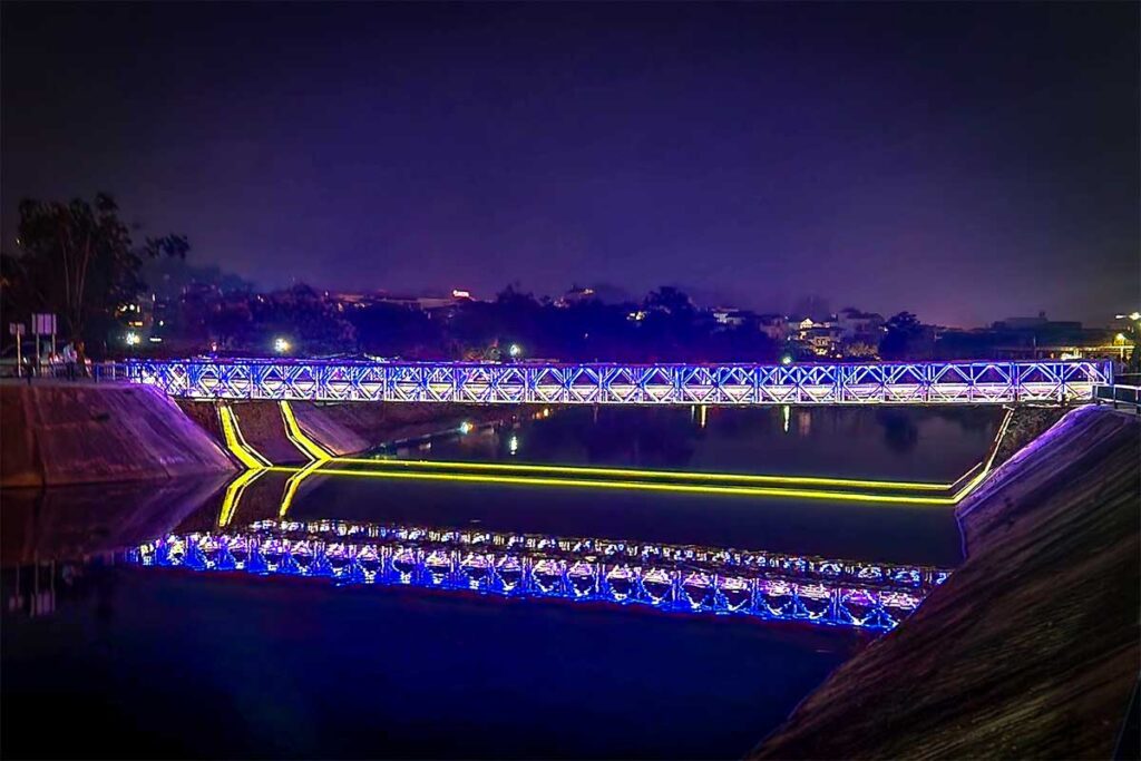 The Muong Thanh Bridge at night with nice LED lights lighting up the bridge and reflect in the river below