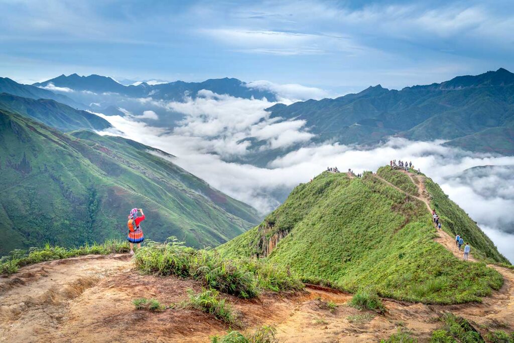 A person trekking over the ridge of a mountain nicknamed Dinosaur Spine in Ta Xua