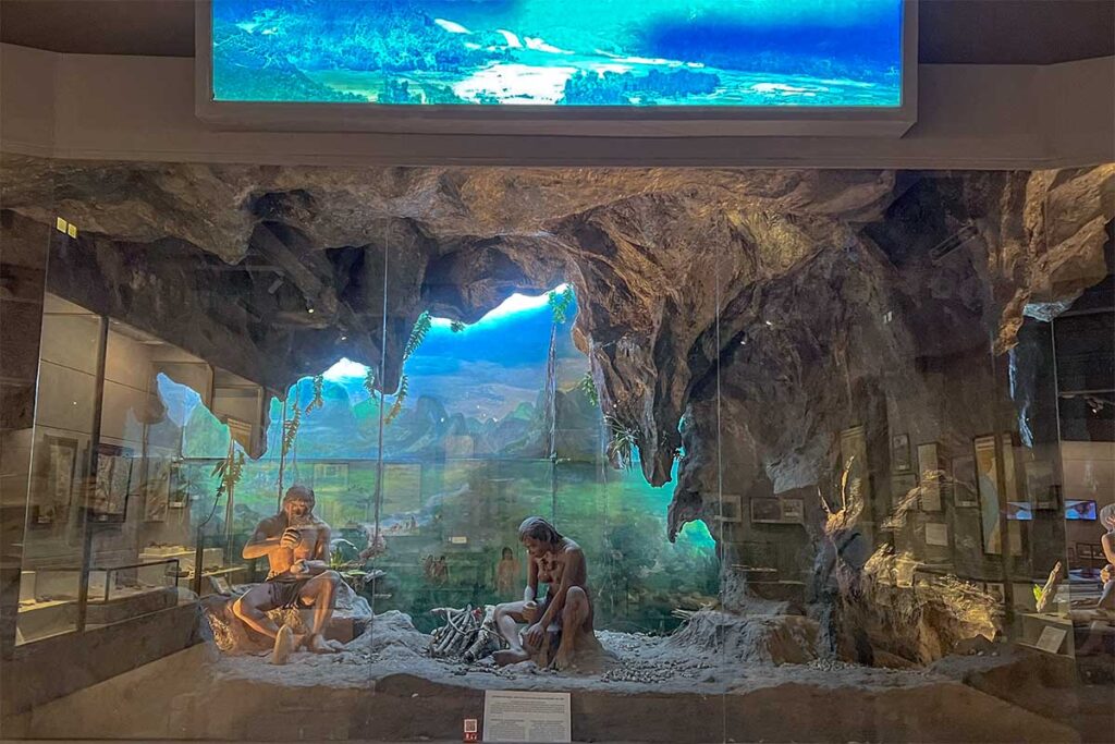 A setup of a cave with prehistoric man (dolls) to show how people lived seen at Vietnam National Museum of History 