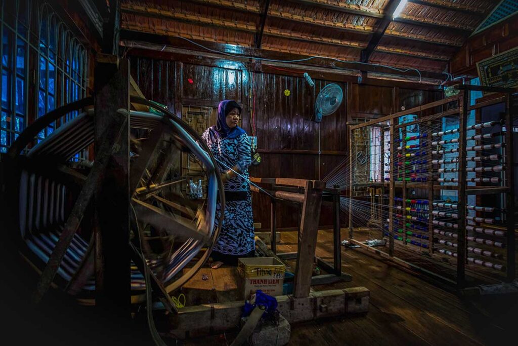 A muslim woman is weaving in her house at Chau Giang Cham Village